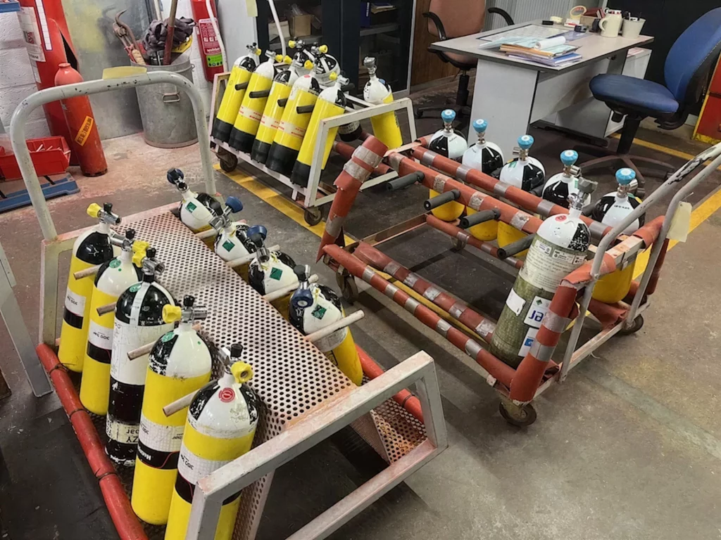Bouteilles d'air comprimé rangées sur les chariots de l'atelier avant requalification