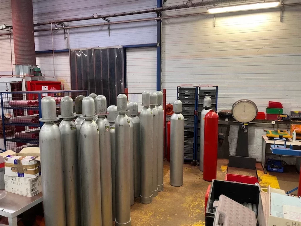 Bouteilles CO2 d'installations fixes alignées à l'atelier, près de la balance de pesée