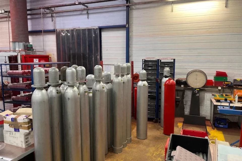 Bouteilles CO2 d'installations fixes alignées à l'atelier, près de la balance de pesée