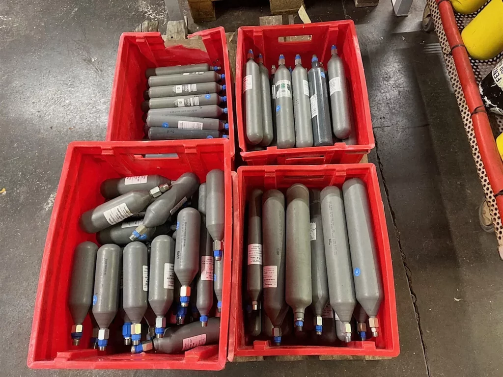 Cartouches de gaz triées dans des bacs à l'atelier