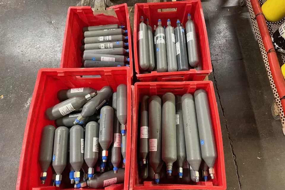 Cartouches de gaz triées dans des bacs à l'atelier