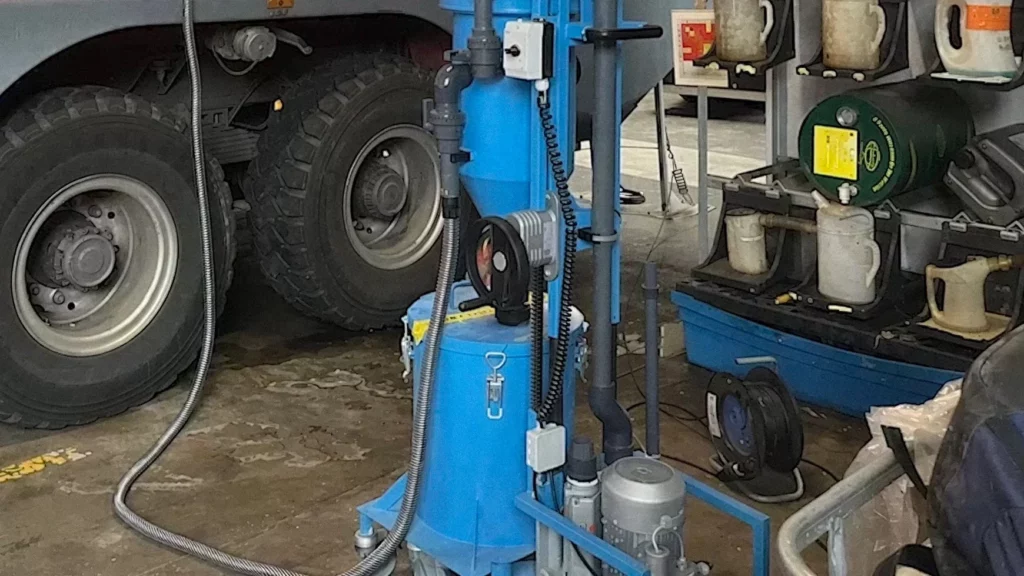 Machine de purge raccordée au réservoir de poudre d'un véhicule d'intervention, au pied du véhicule